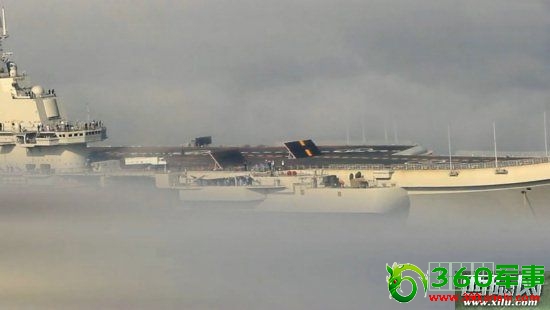 正在缓缓入港的瓦良格航母,其甲板上的两块供舰载机起降使用的挡焰板竖起